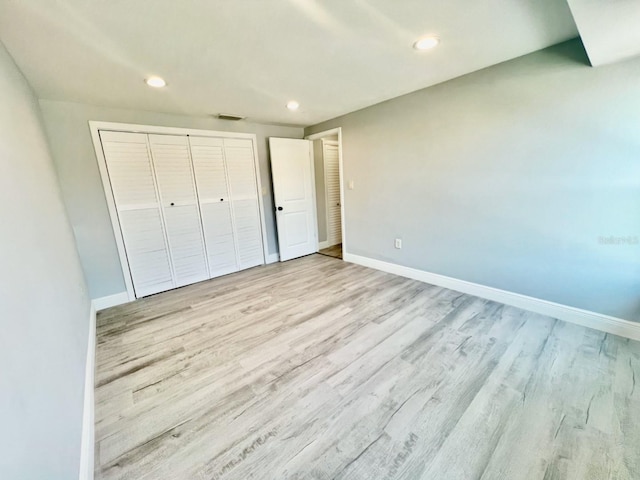 unfurnished bedroom featuring light hardwood / wood-style floors and a closet