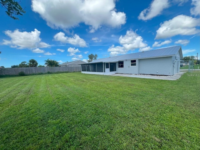 back of property with a sunroom and a yard