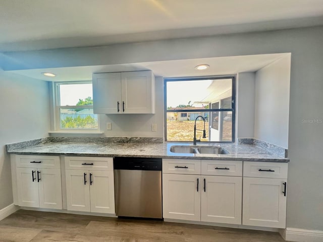 kitchen featuring white cabinets, dishwasher, light stone countertops, and sink