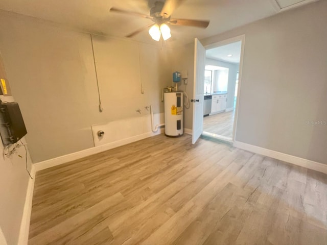 clothes washing area featuring electric water heater, ceiling fan, and light wood-type flooring