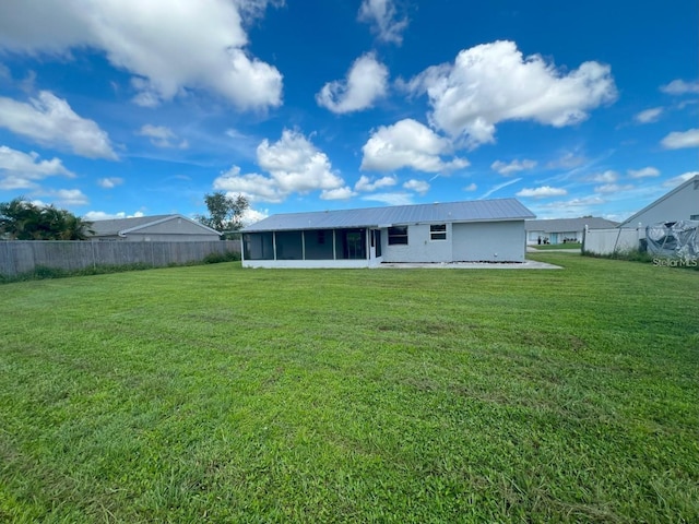 rear view of house with a lawn and a sunroom