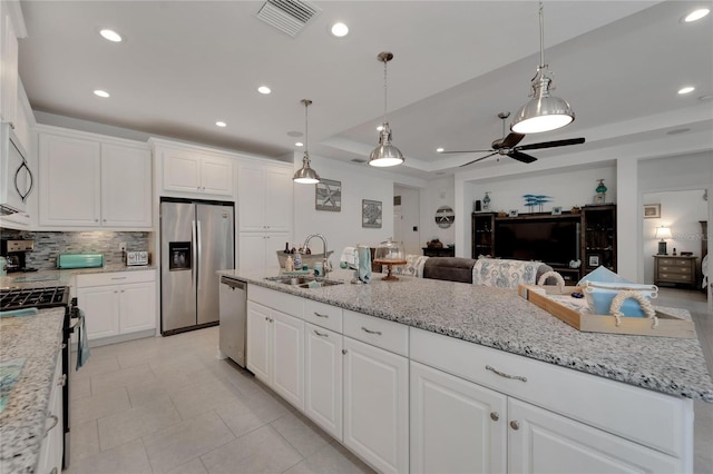 kitchen with sink, white cabinets, a raised ceiling, and appliances with stainless steel finishes