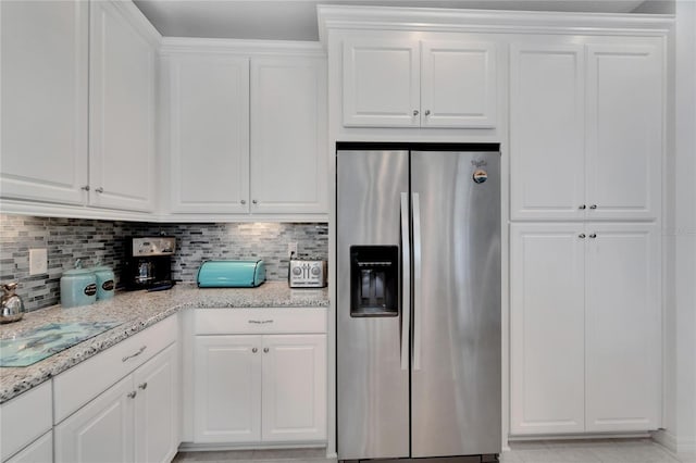 kitchen with stainless steel fridge with ice dispenser, white cabinetry, and tasteful backsplash