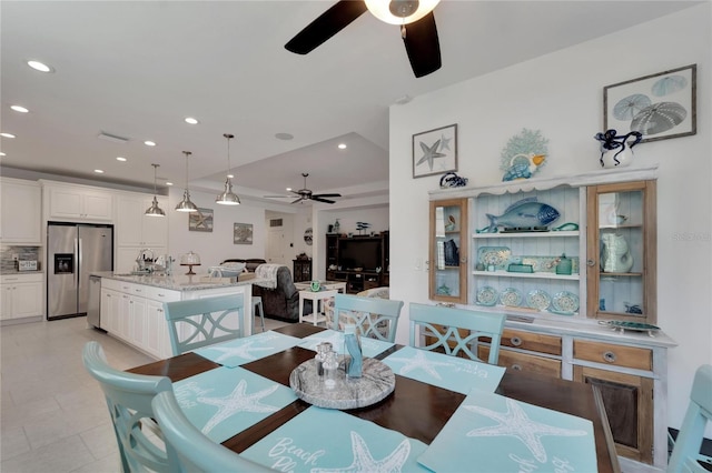 dining area with ceiling fan and sink