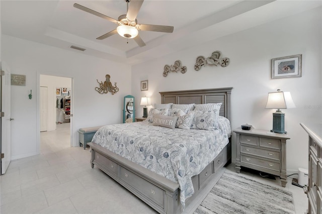 bedroom with a raised ceiling and ceiling fan