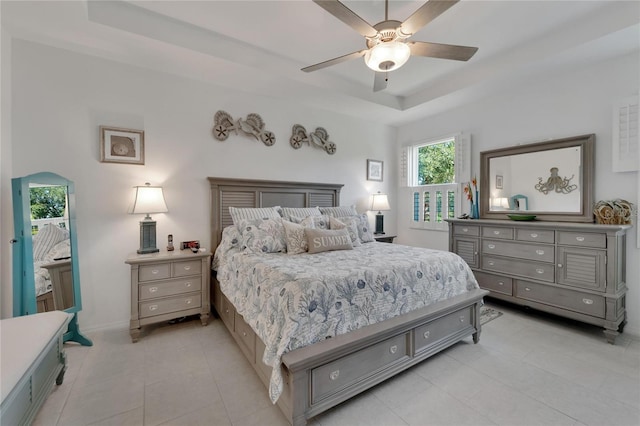 bedroom with ceiling fan and a tray ceiling