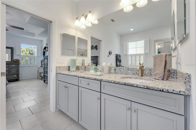 bathroom with tile patterned flooring, a healthy amount of sunlight, and vanity