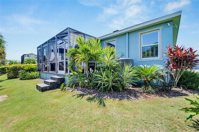 view of property exterior with a lanai and a lawn