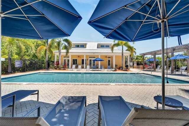 view of swimming pool with a patio area, ceiling fan, and a pergola