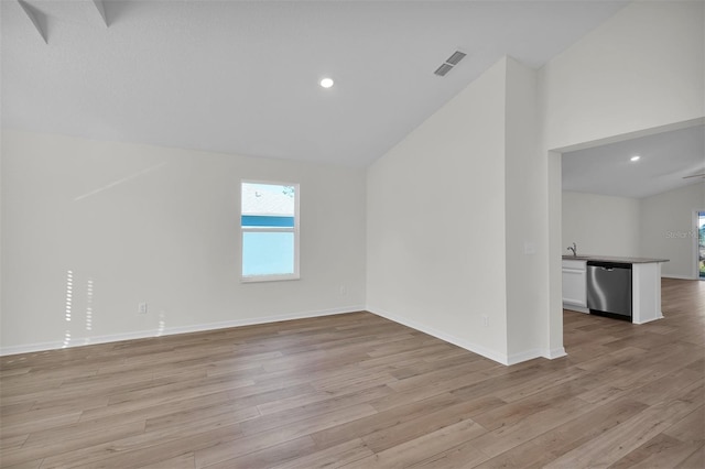 unfurnished room with light wood-type flooring and vaulted ceiling