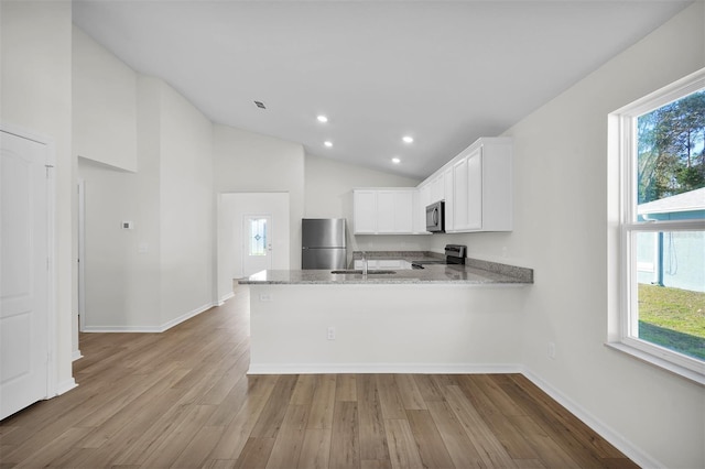 kitchen featuring white cabinets, plenty of natural light, kitchen peninsula, and stainless steel appliances