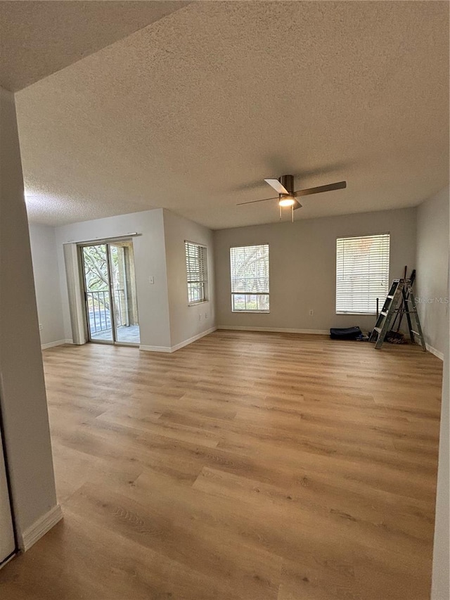 unfurnished room with ceiling fan, light hardwood / wood-style flooring, and a textured ceiling