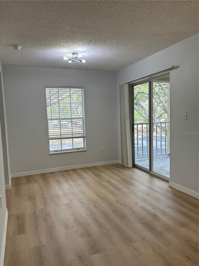 spare room with a textured ceiling and wood-type flooring