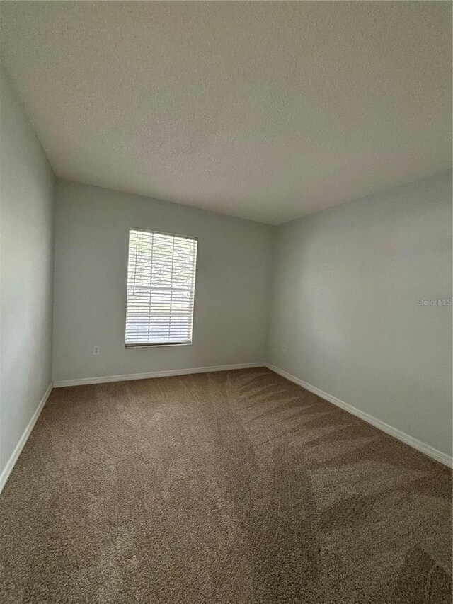 carpeted spare room featuring a textured ceiling