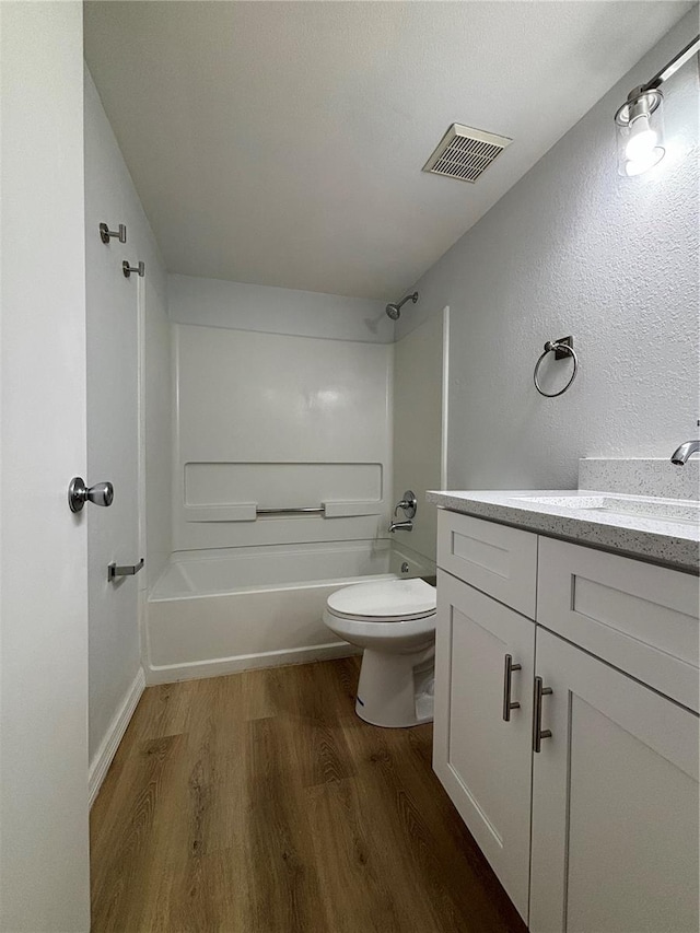 full bathroom with washtub / shower combination, hardwood / wood-style flooring, toilet, and vanity