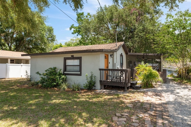 view of front of property featuring a deck and a front lawn