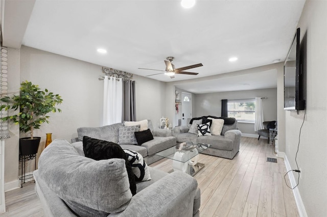 living room featuring ceiling fan and light hardwood / wood-style floors