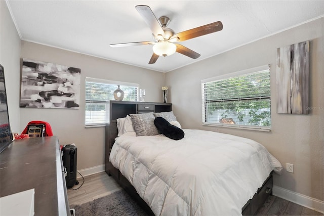 bedroom with ceiling fan, dark hardwood / wood-style flooring, and crown molding