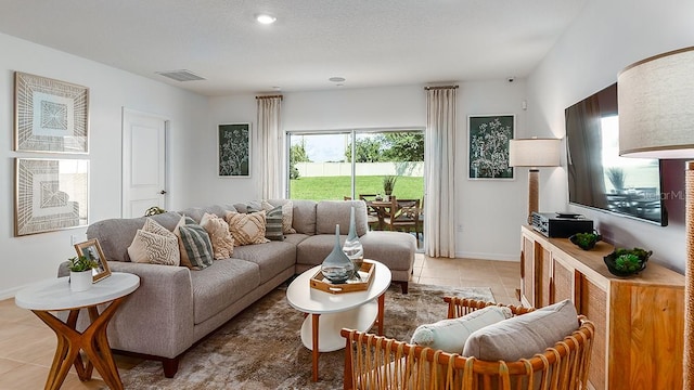 living room with light tile patterned flooring and a textured ceiling