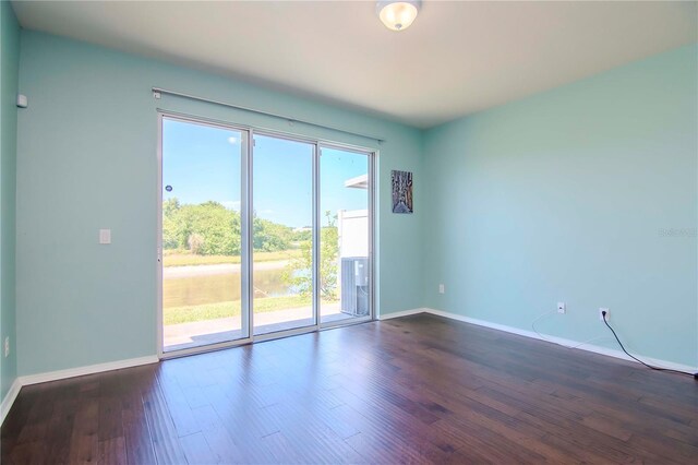 unfurnished room featuring plenty of natural light and dark hardwood / wood-style flooring