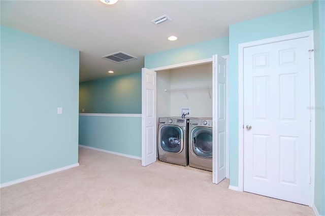 laundry room featuring washing machine and clothes dryer and light colored carpet