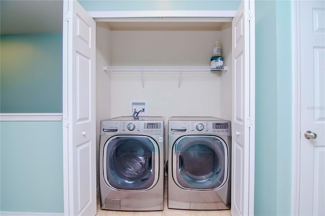 clothes washing area with washing machine and dryer and tile patterned flooring