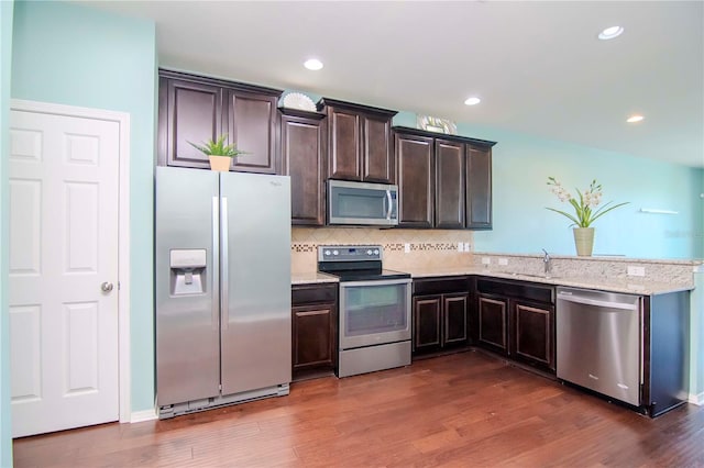 kitchen featuring appliances with stainless steel finishes, dark hardwood / wood-style flooring, and dark brown cabinetry