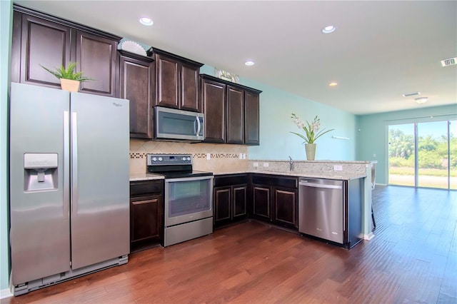 kitchen with dark brown cabinetry, dark hardwood / wood-style floors, and appliances with stainless steel finishes