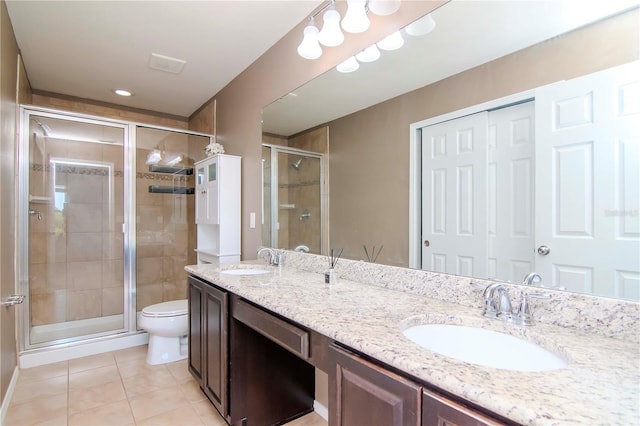 bathroom featuring tile patterned floors, vanity, toilet, and a shower with shower door