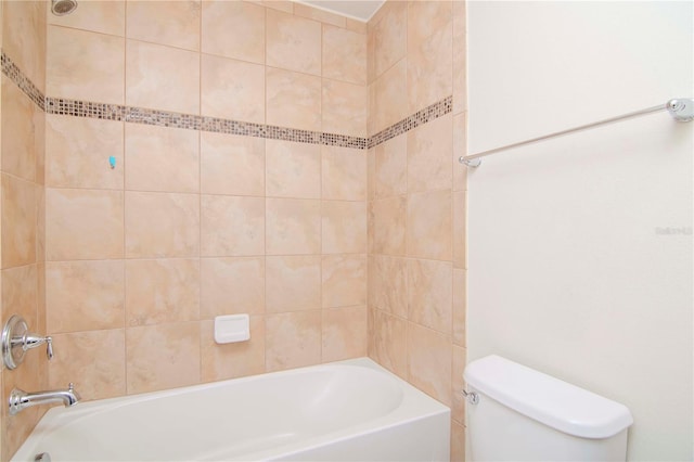 bathroom with toilet and tiled shower / bath