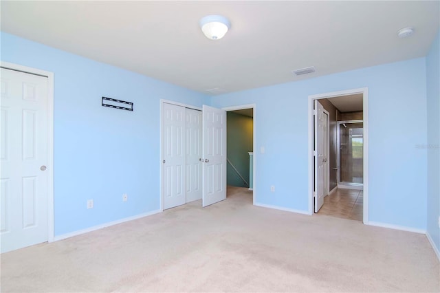 unfurnished bedroom with light colored carpet and ensuite bath