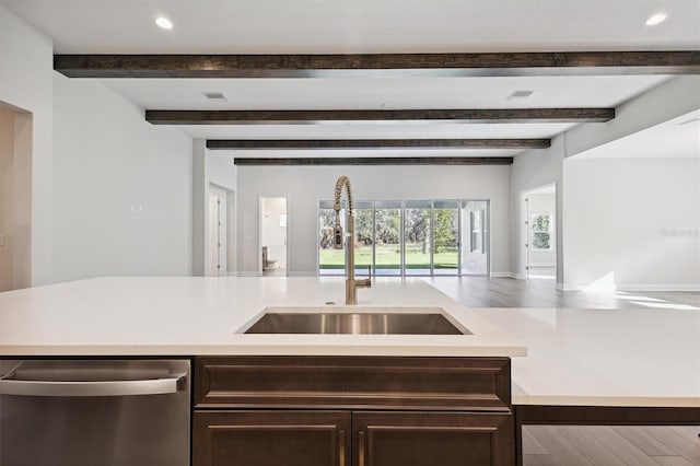 kitchen with dark brown cabinetry, sink, stainless steel dishwasher, and hardwood / wood-style flooring