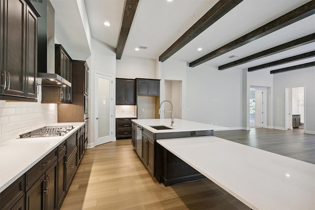 kitchen featuring beam ceiling, light hardwood / wood-style floors, and sink