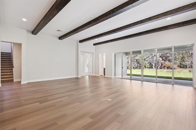 unfurnished living room with beamed ceiling and light hardwood / wood-style floors