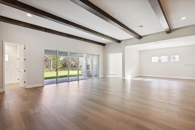 unfurnished living room featuring beam ceiling, hardwood / wood-style floors, and an inviting chandelier