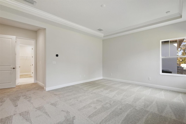 unfurnished room with light colored carpet, crown molding, and a tray ceiling