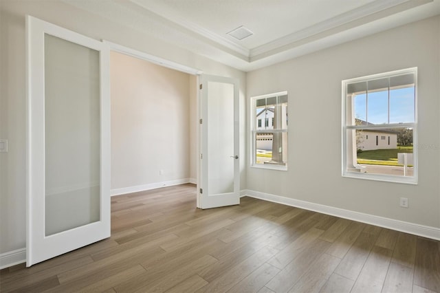 unfurnished bedroom with light hardwood / wood-style floors, ornamental molding, and french doors