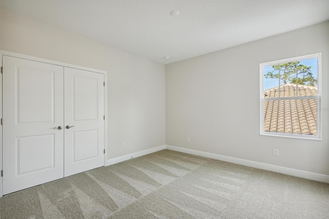 unfurnished bedroom featuring carpet flooring and a closet