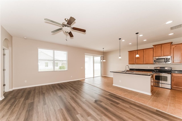 kitchen featuring sink, hanging light fixtures, ceiling fan, dark hardwood / wood-style flooring, and stainless steel appliances