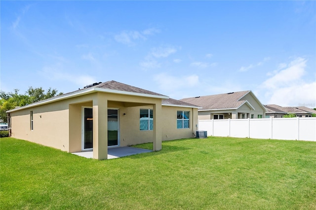 rear view of property with a yard, a patio, and central air condition unit