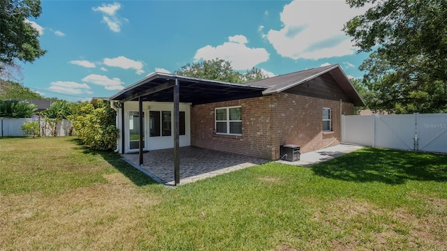 back of house with a lawn and a patio area