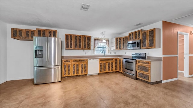 kitchen with pendant lighting, stainless steel appliances, and sink