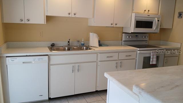 kitchen featuring white cabinetry, white appliances, sink, and light tile patterned floors