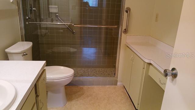 bathroom featuring toilet, vanity, and walk in shower