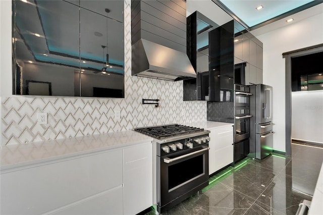 kitchen featuring white cabinets, high quality appliances, wall chimney range hood, and backsplash