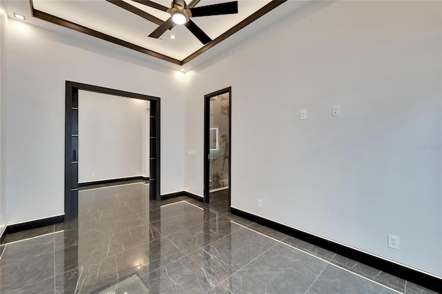 unfurnished room featuring a tray ceiling, ceiling fan, and ornamental molding