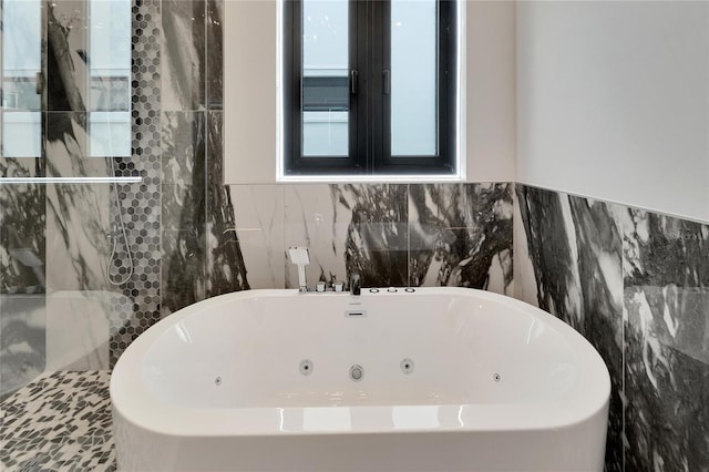 bathroom featuring a bathtub and tile walls