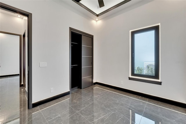 unfurnished bedroom featuring ceiling fan, ornamental molding, and a closet