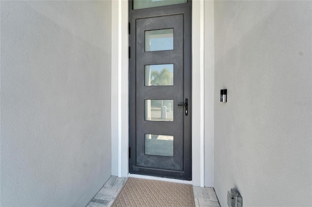 property entrance with stucco siding