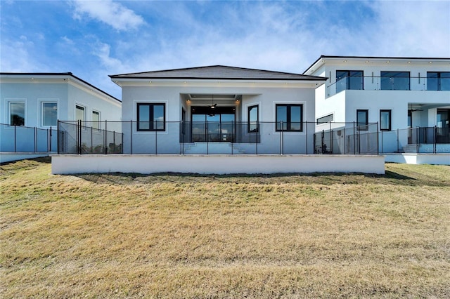 rear view of house with french doors, fence, and stucco siding